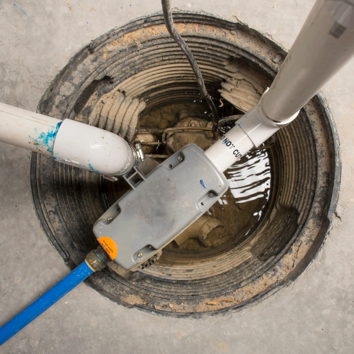 Robot sewer inspection device inserted into an open manhole, with blue and white pipes and muddy water inside nearby rims.